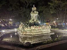 Mermaid fountain in the Parque Central of Antigua Guatemala surrounded by colonial buildings