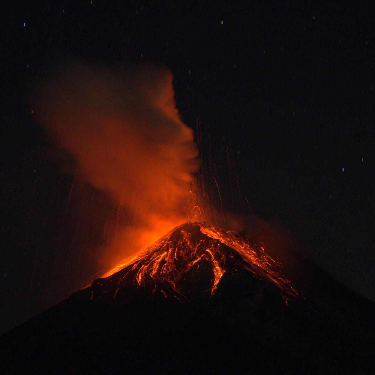 Volcan de Fuego erupting at night with glowing lava visible