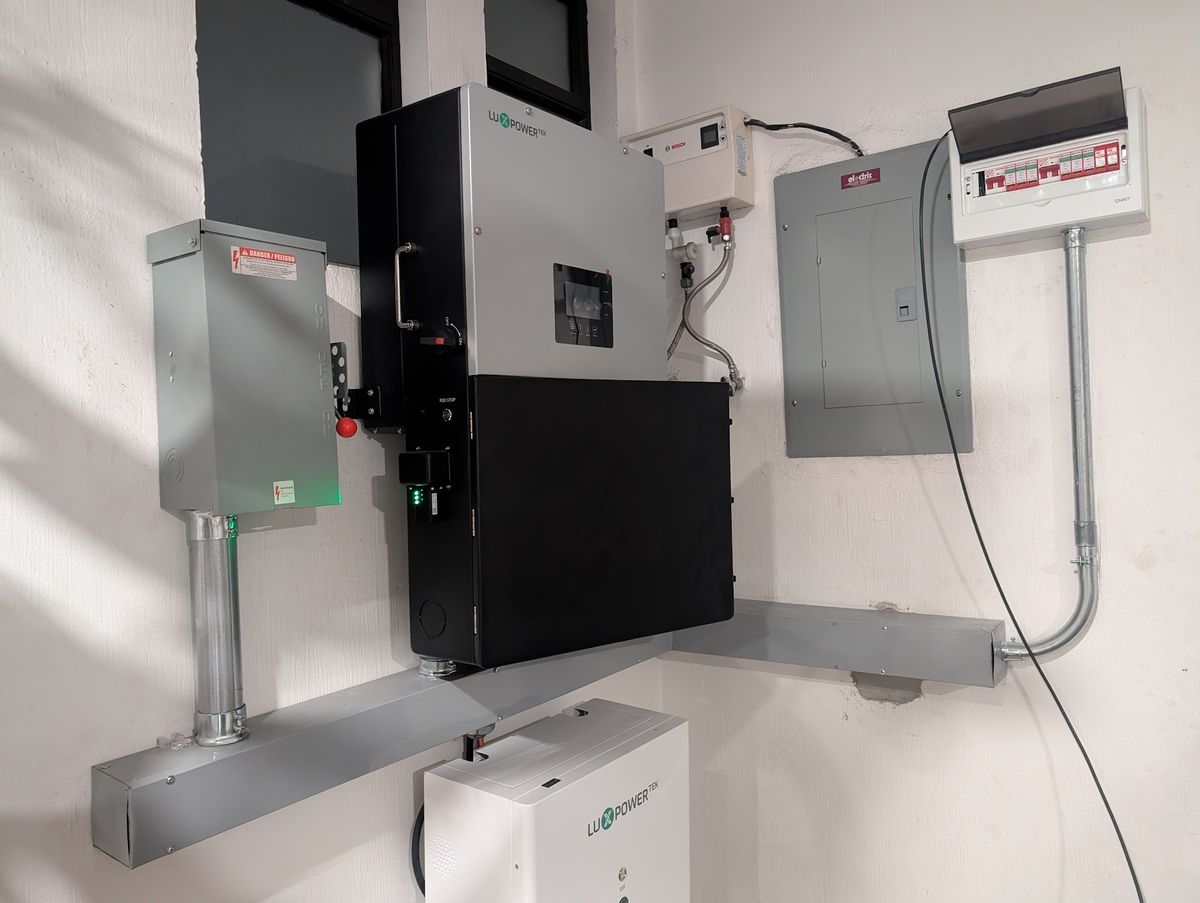 Inversor Luxpowertek y bateria POWERGEM montados en pared con paneles de breakers en Guatemala