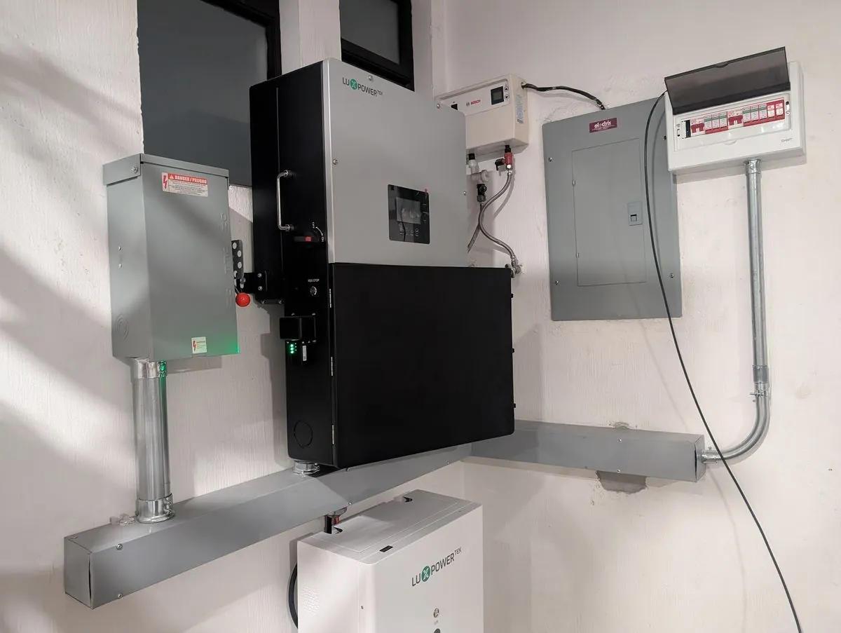 Inversor Luxpowertek y bateria POWERGEM montados en pared con paneles de breakers en Guatemala