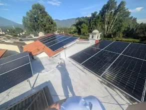 Primer plano de 16 paneles bifaciales JA Solar 620W montados en un techo en Guatemala