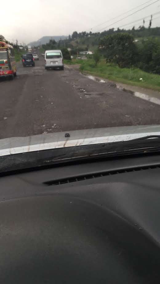 Calle llena de baches en lluvia