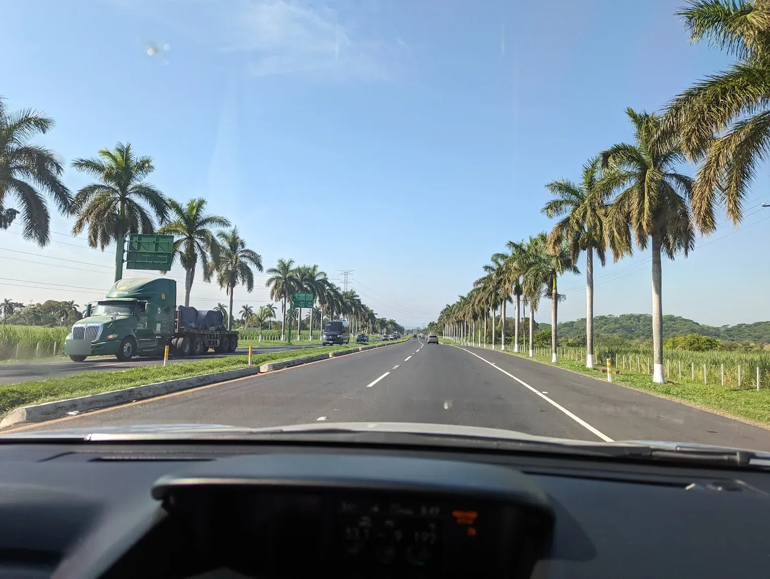 Carretera de cuatro carriles bordeada de palmeras entre canaverales en Escuintla