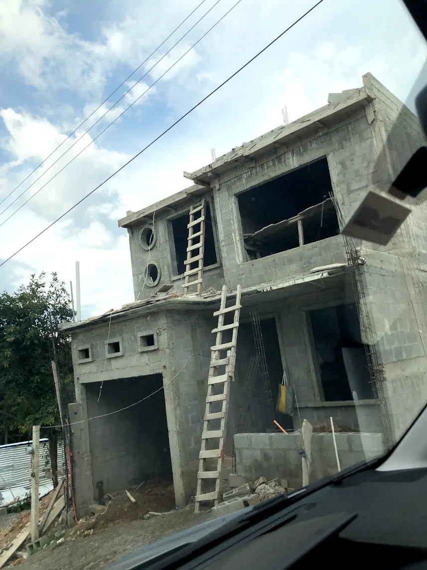 Casa de dos niveles en obra gris con muros de block y escaleras de madera