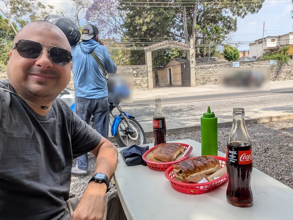 Estuardo Enriquez eating shucos at a roadside stand in Antigua Guatemala